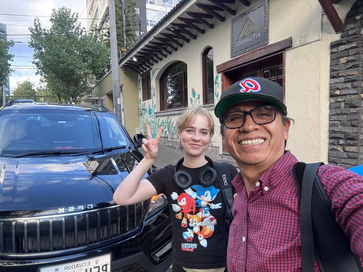 Juan Carlos with a traveler next to the SUV after pickup